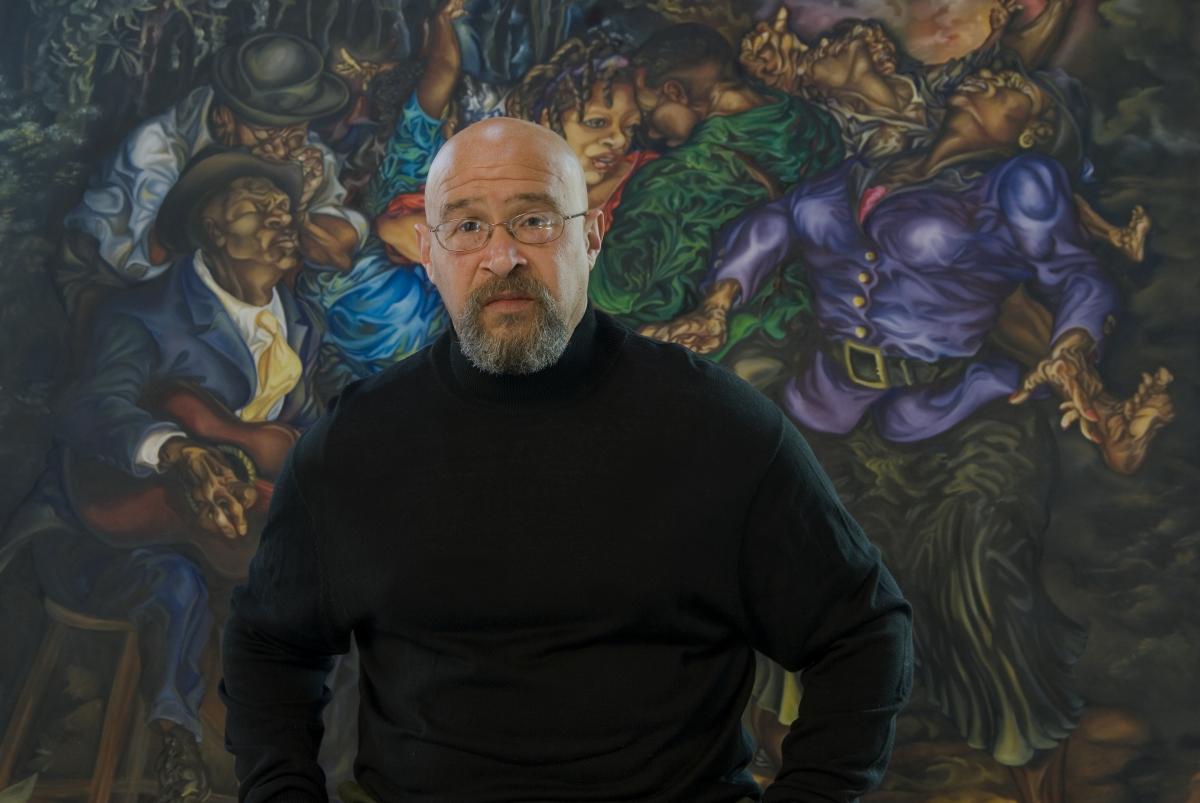 Rik Freeman standing in front of one of his paintings