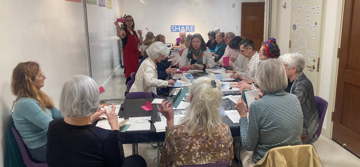 Photograph of people making sketchbooks in the art workshop