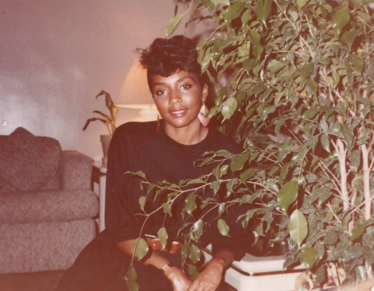 Vintage photograph of woman sitting in living room next to tree