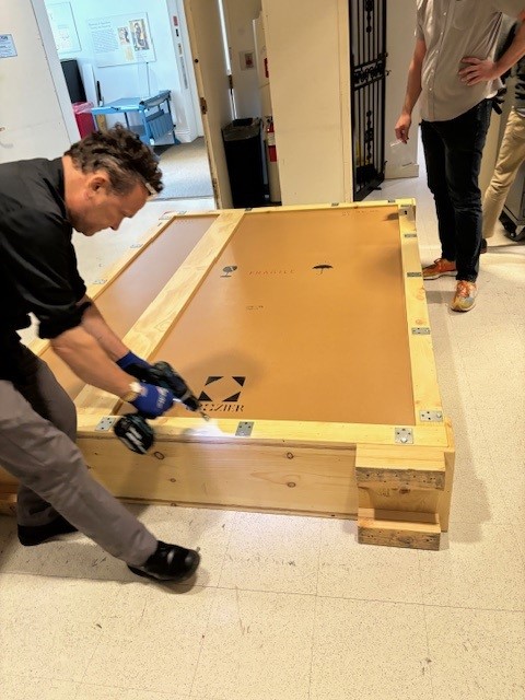 Photograph of preparator opening crate