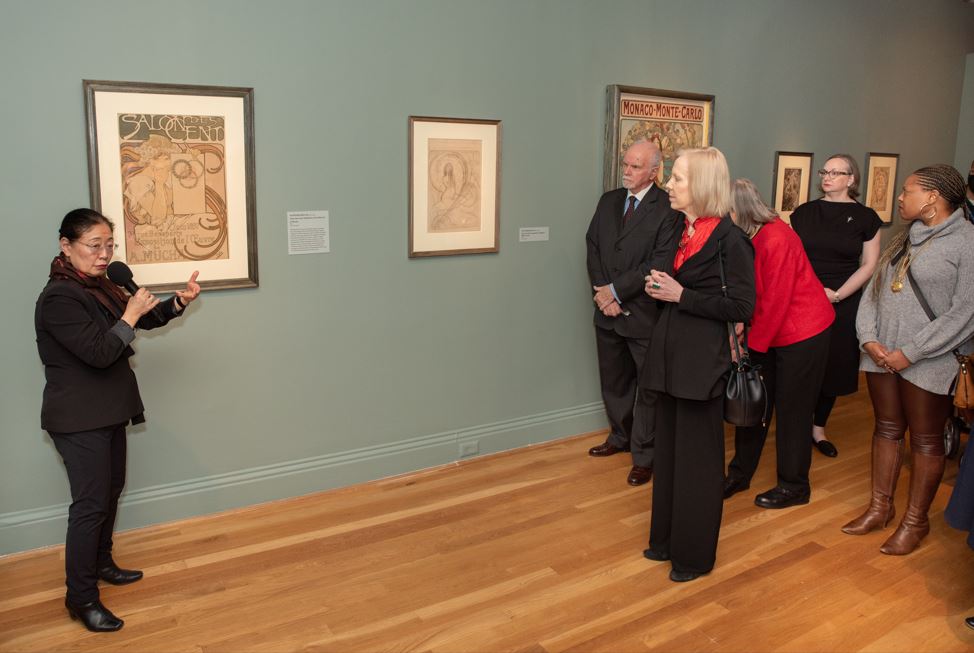 Tomoko Sato giving a talk about Alphonse Mucha's artwork in a gallery