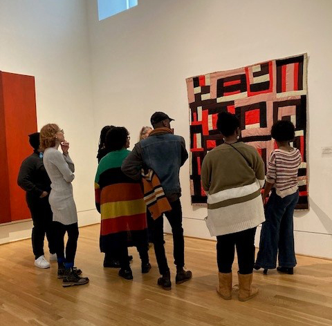 Gee's Bend performers listening to a talk about a Gee's Bend quilt in the galleries