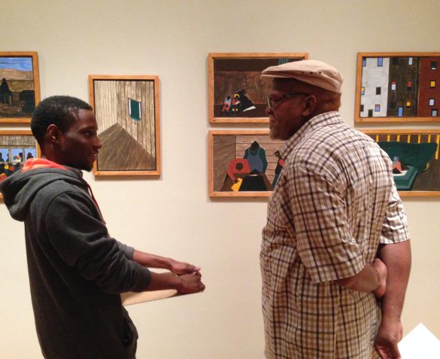 A student asks an elder about his life while looking at The Migration Series.  Photo: Andrea Kim Taylor