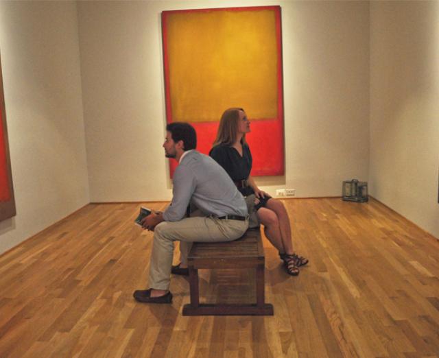 Two visitors sit on a bench in the middle of the Rothko Room at the Phillips
