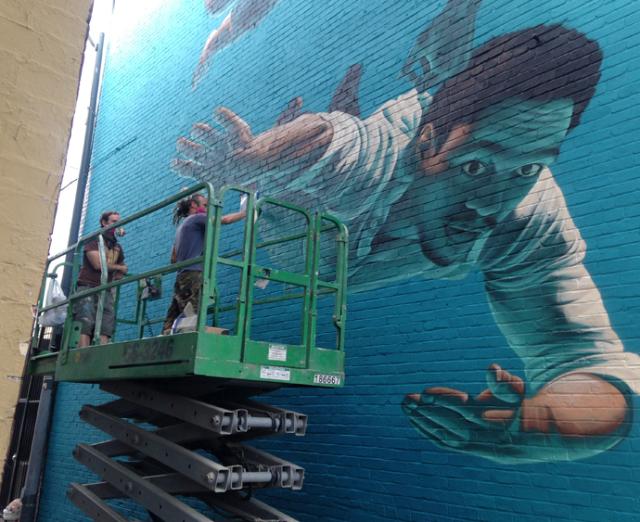 Artist James Bullough on day 4 creating a mural at 905 U Street, NW