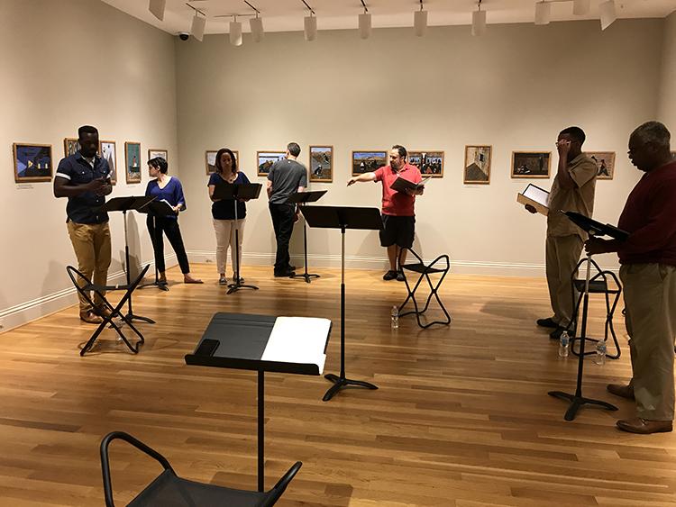 From left to right: Desmond Bing, Nora Achrati, Natalie Graves Tucker, Jeff Allin, Derek Goldman (director), James Johnson, and Craig Wallace. Rehearsing Terrance Arvelle Chisholm’s “In Constant Pursuit” inspired by Panel no. 3: From every southern town migrants left by the hundred to travel north.