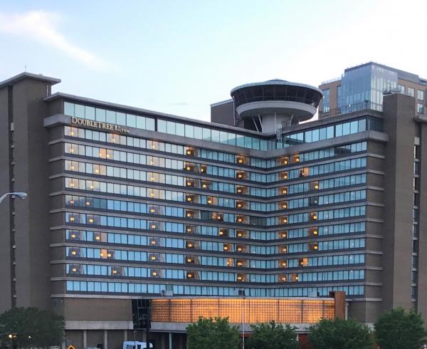 Photograph of large building with windows spelling out "KIND"