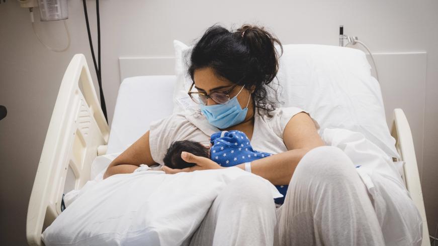 Photograph of mother holding newborn baby in the hospital