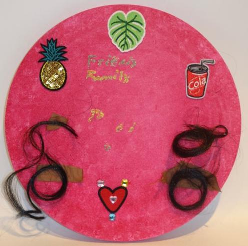 A circle with a variety of stickers and hair pieces.