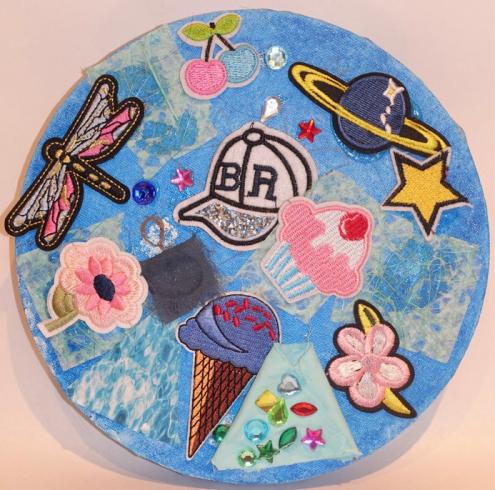 Circle with a variety of colorful fabric stickers and gems.