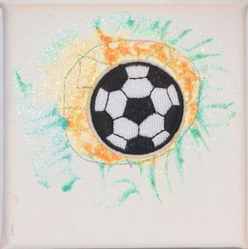 A soccer sticker in a circle of orange and green spikes.