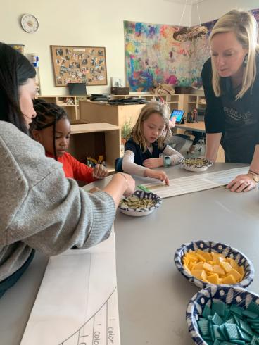 Phillips staff helping students place mosaic tiles.