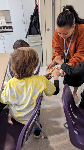 Phillips educator shows students mosaic in the art workshop.