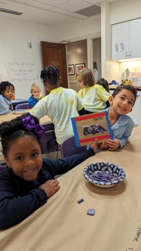 Students holding up their mosaic piece.